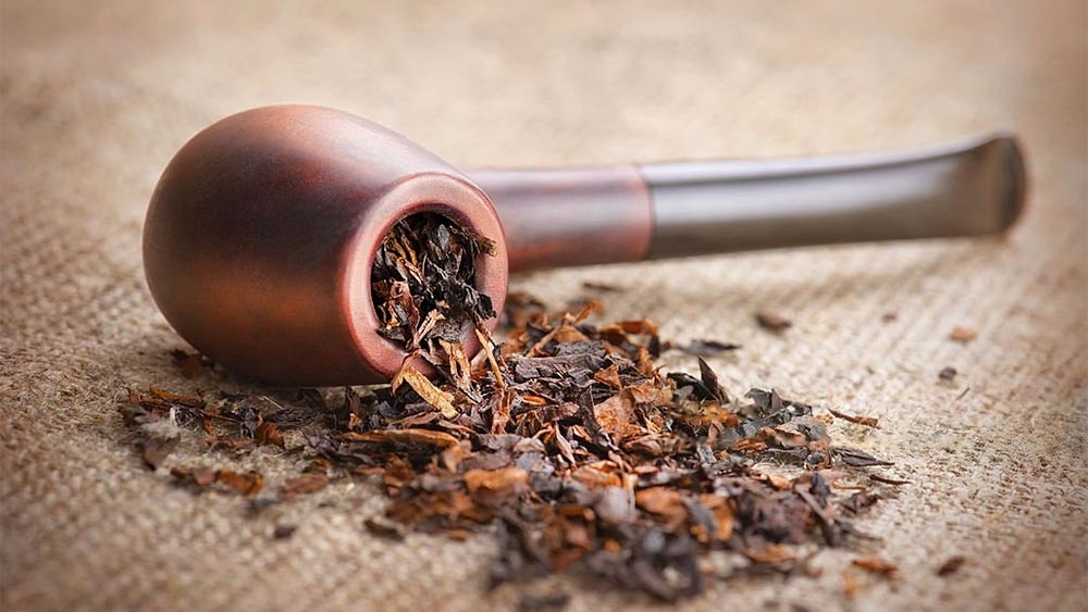 pipa din briar rasturnata cu tutun Peterson iesind din ea